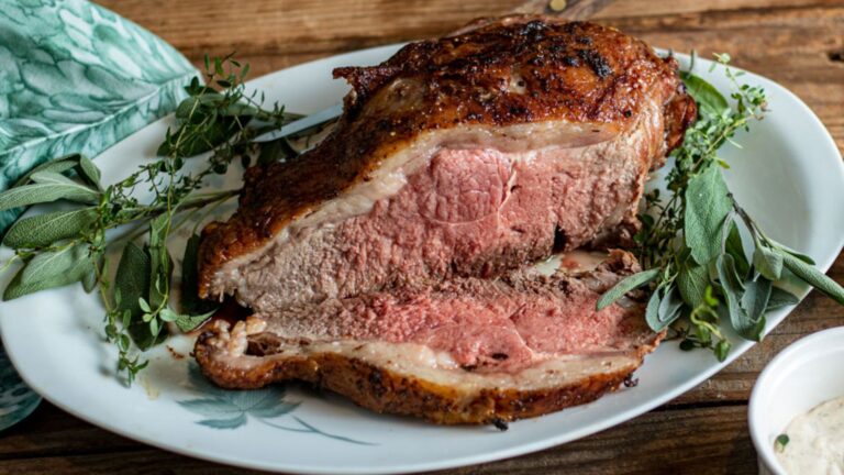 Large beef loin roast with a slice cut off on a platter.