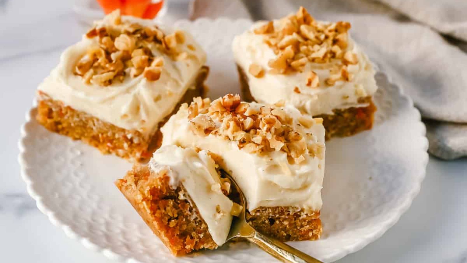 3 carrot cake on a plate with spoon.