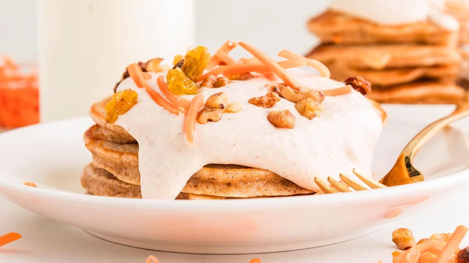 Carrot cake pancakes with peanuts and grated carrots filling on top.