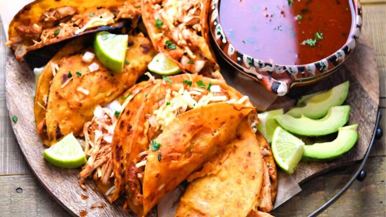 Chicken birria tacos with dip on the side.