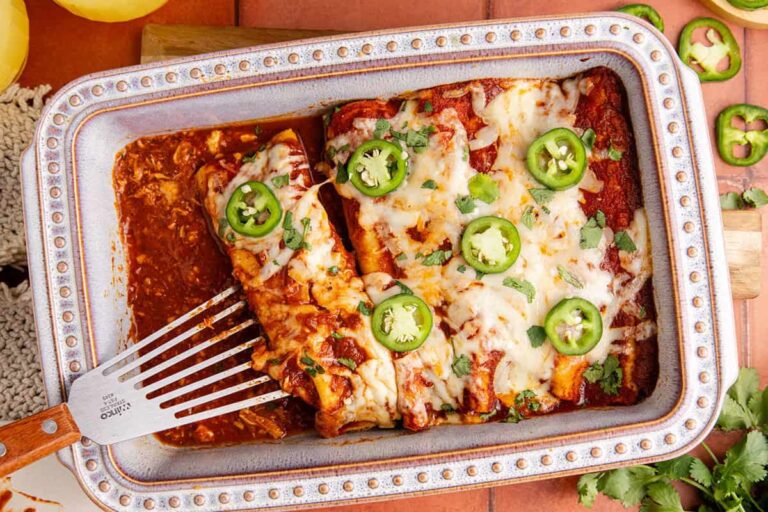Chicken enchiladas in a casserole dish.