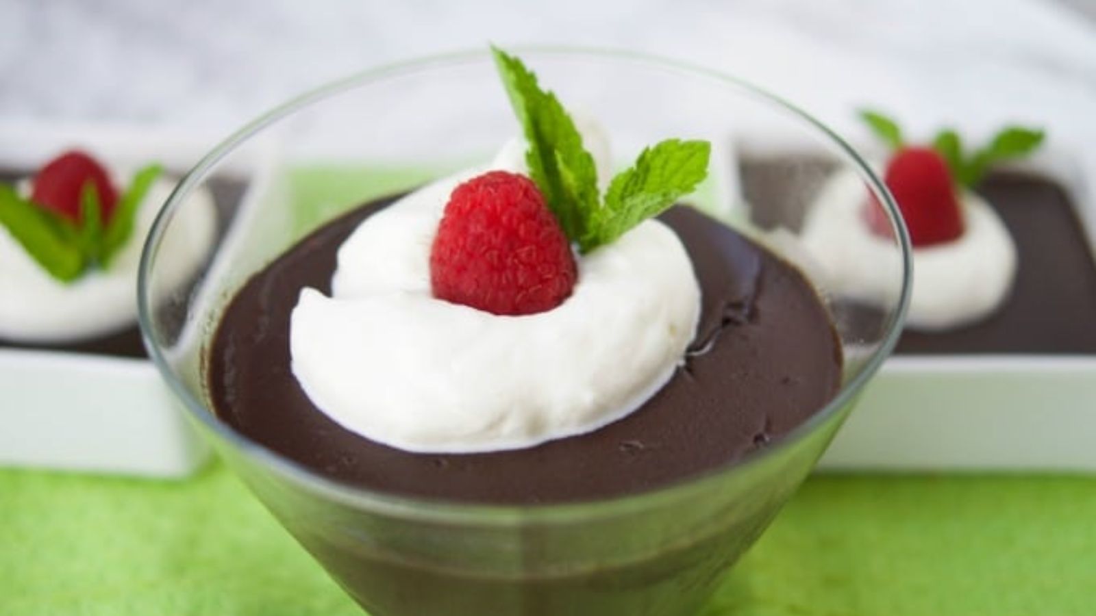 Chocolate pudding with strawberry topping in a glass.