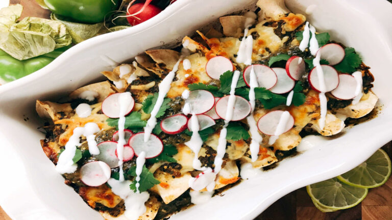 White casserole dish with enchiladas.