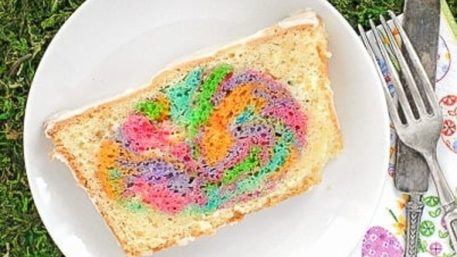 A sliced of rainbow egg cake on a plate.