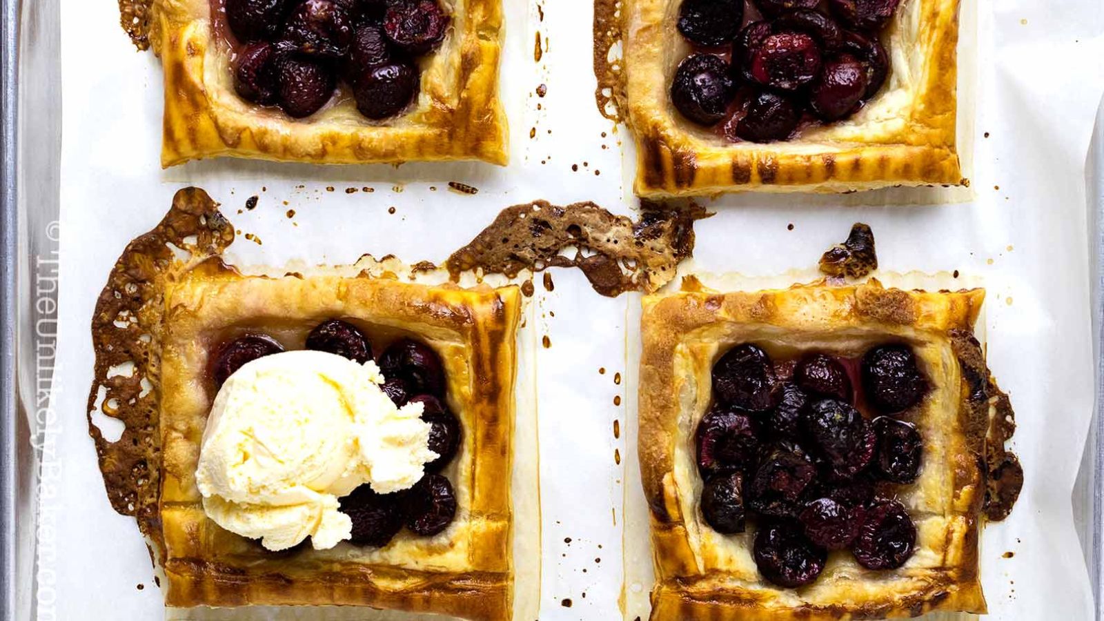 Mini cherry galettes with a scoop of ice cream on one.