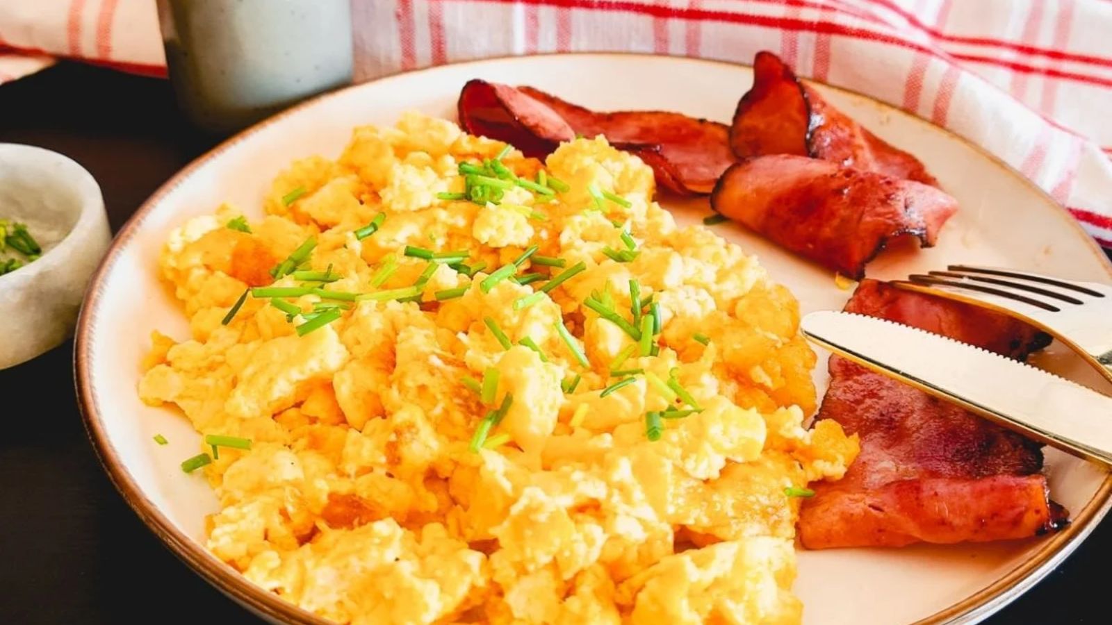 Scrambled egg and bacon on a plate.