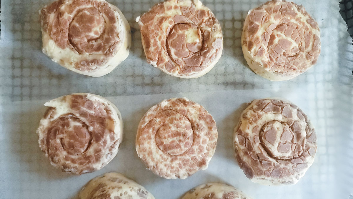 Cinnamon rolls on air fryer basket.