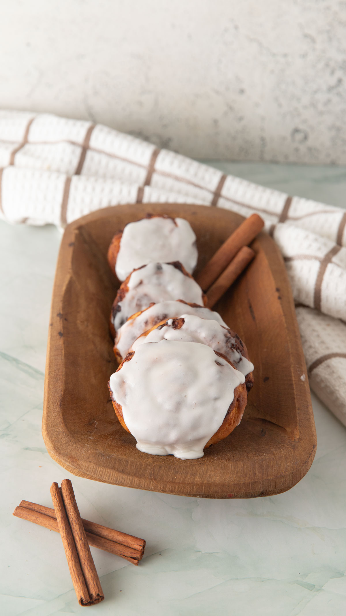 Cinnamon rolls layed out in a wooden bowl.
