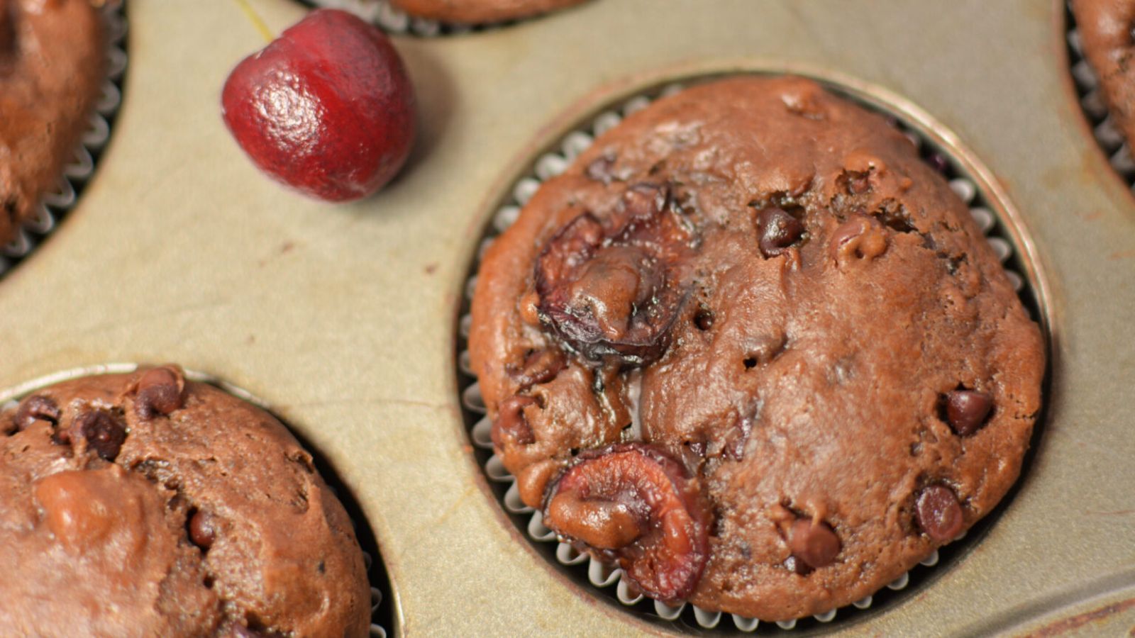 Chocolate cherry muffins in baking pan.

