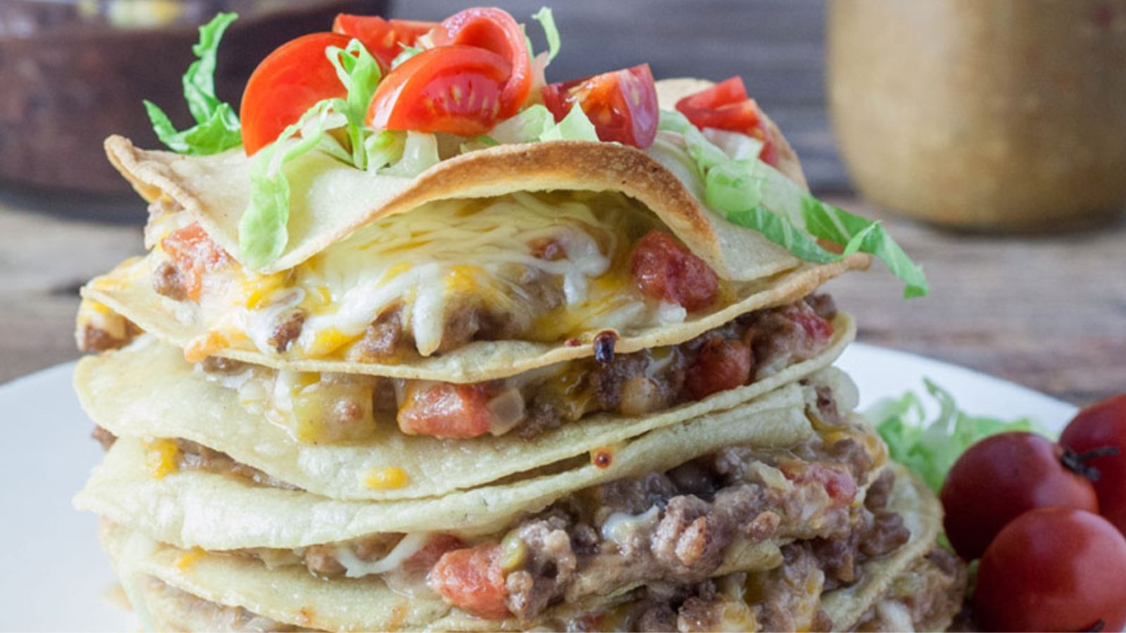 Vintage stacked enchiladas  garnished with lettuce and tomatoes.