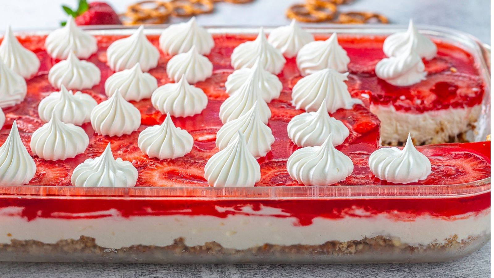 Colorful strawberry dessert dotted with whipped cream.