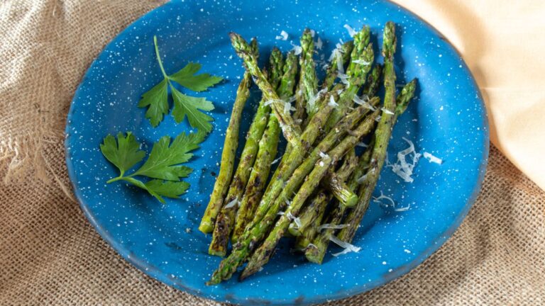 Grilled asparagus on a blue plate.