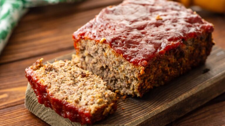 Sliced classic meatloaf on a wooden board.