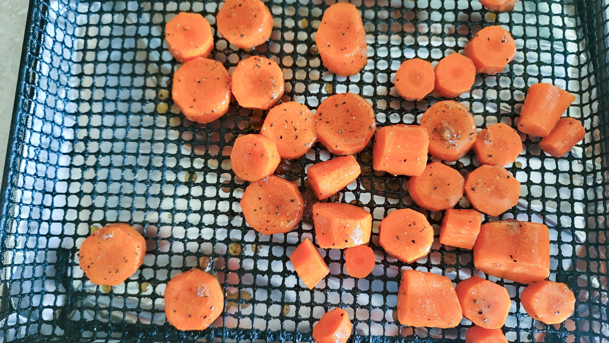 Carrots arranged on an air fryer basket.