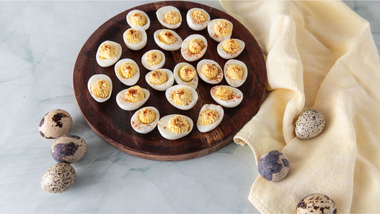 Deviled quail eggs on a wooden plate.