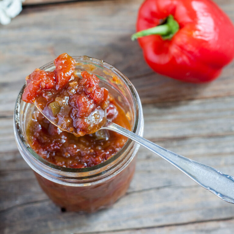 Colorful Oscar relish next to a fresh red pepper.