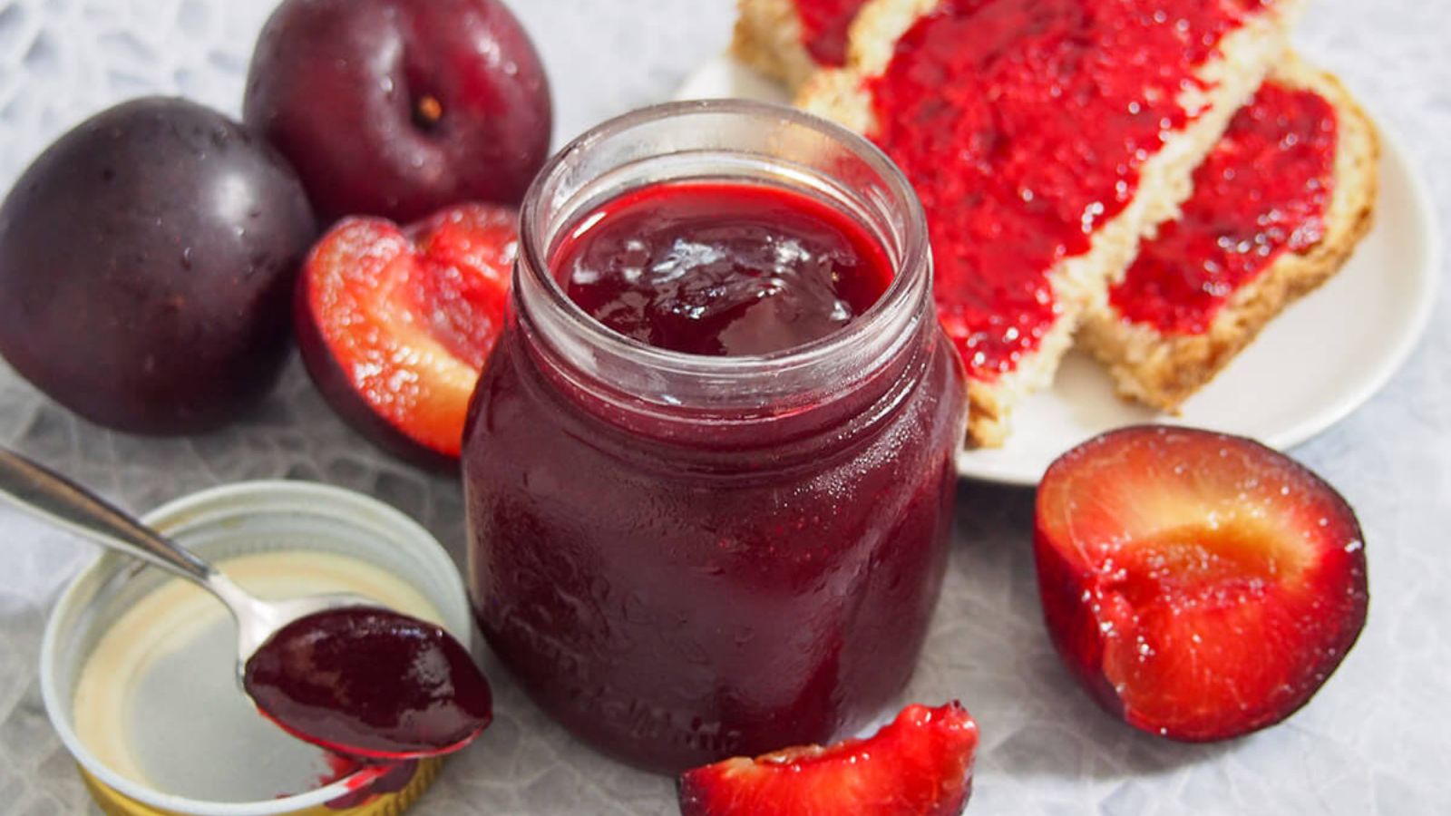Plum jam in a jar and spread on toast.