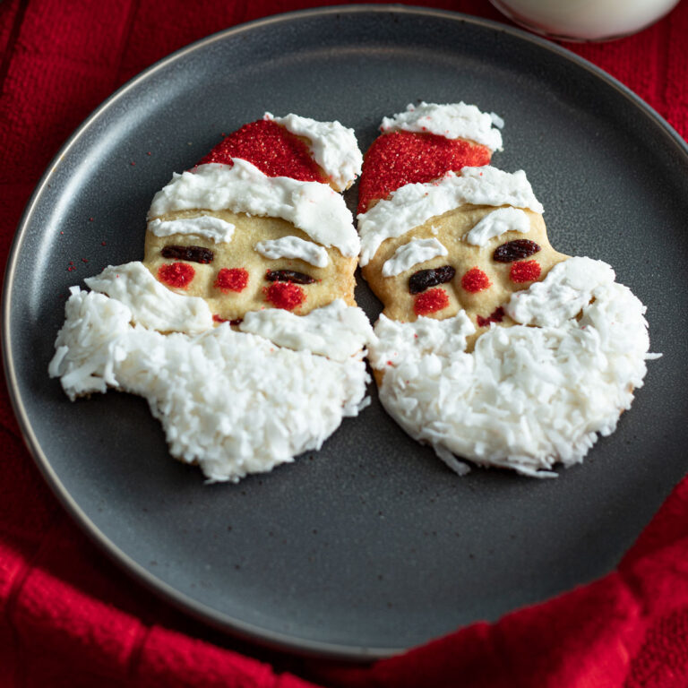 Santa Claus shaped cookies with a bite taken out.