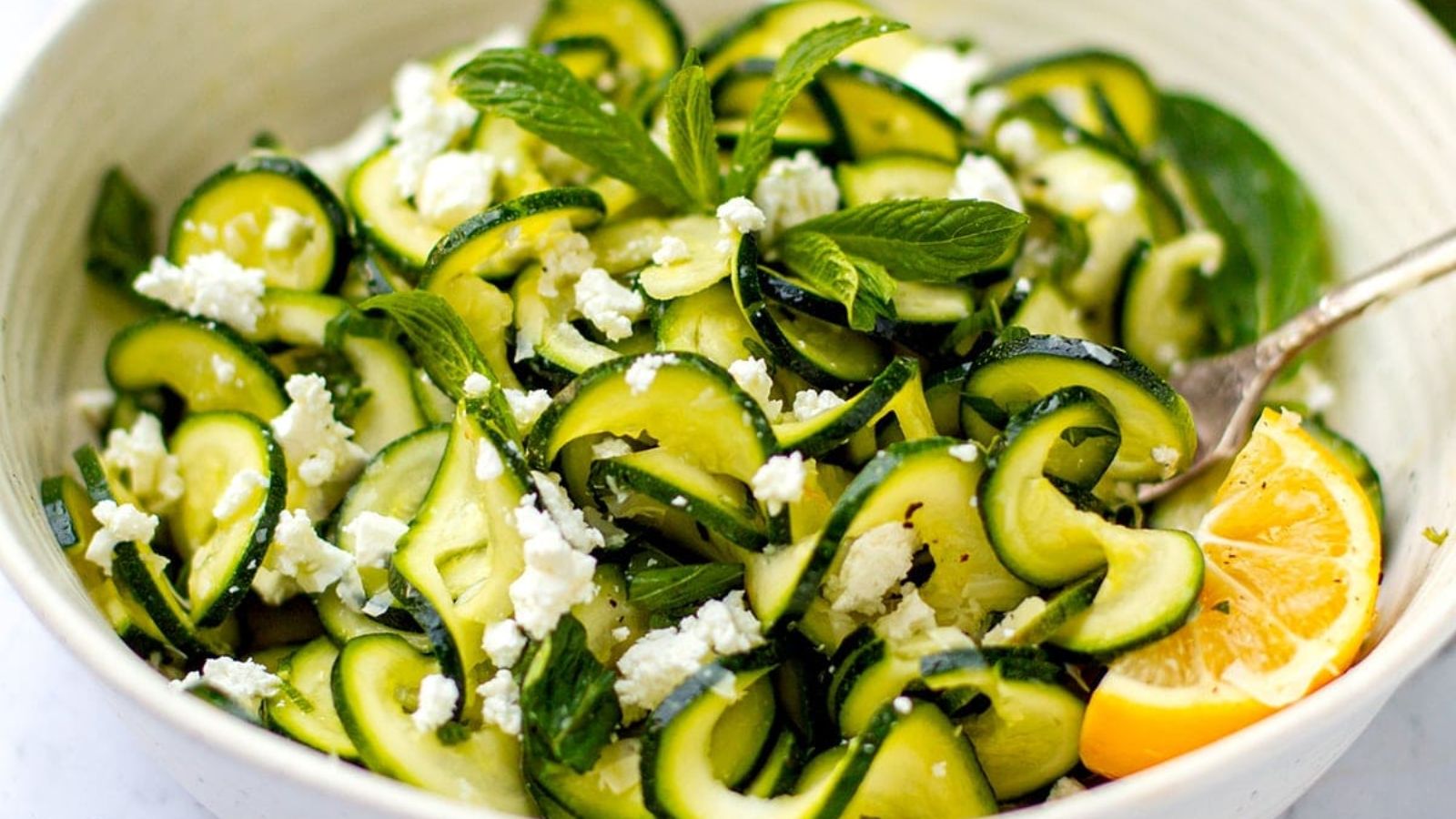 Close up shot of Zucchini Salad With Lemon & Mint on a bowl.