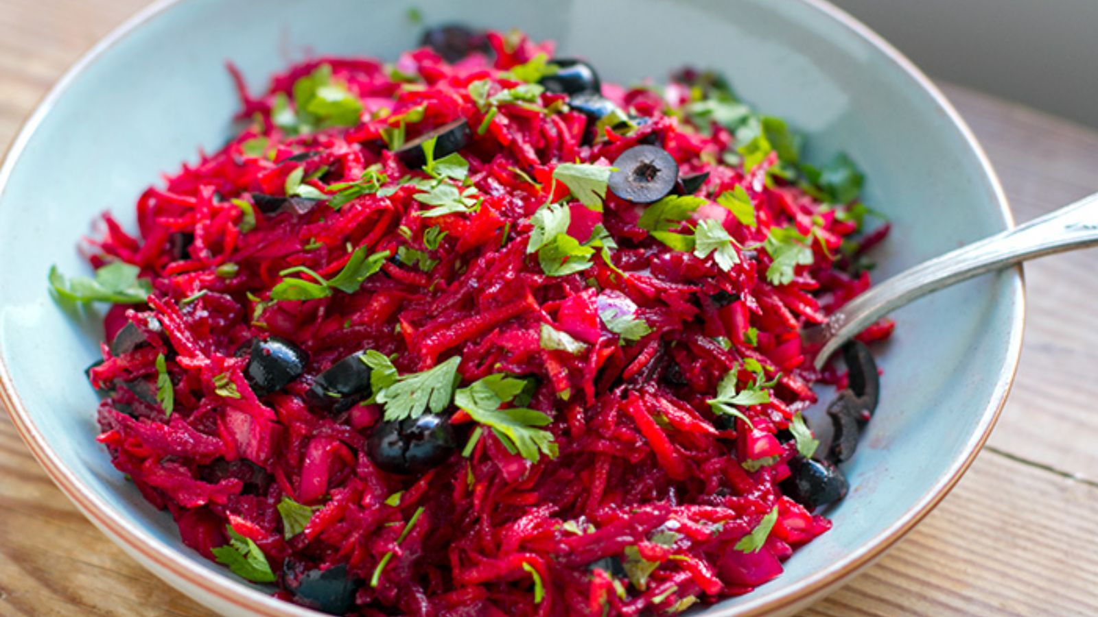 Beet slaw with olives in a bowl.