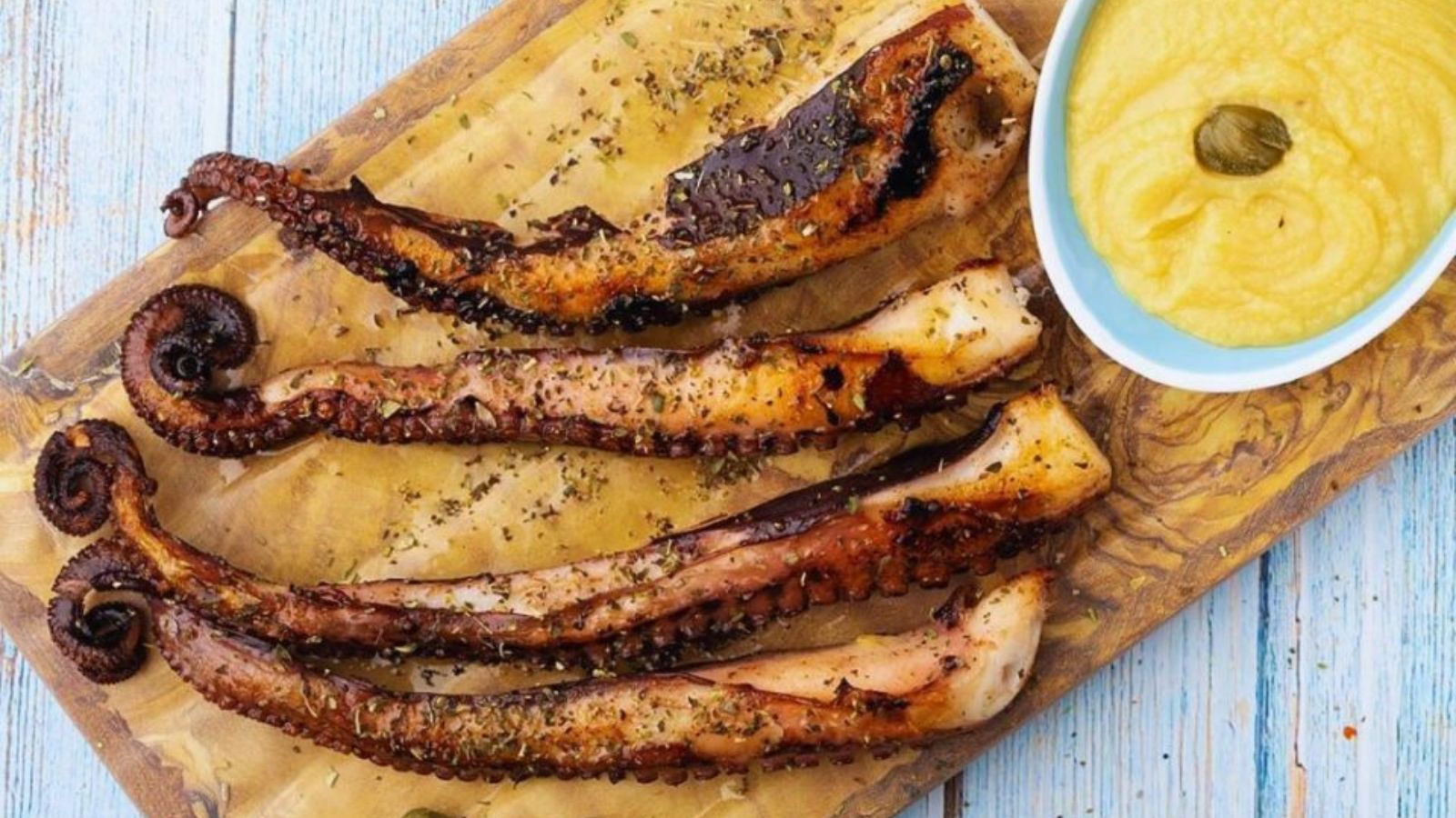 Grilled octopus with lemon on a wooden board