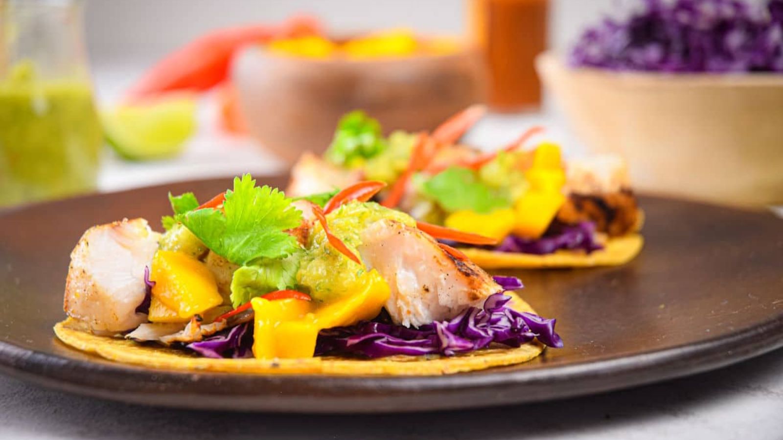 Close up shot of grilled halibut tacos on a plate.