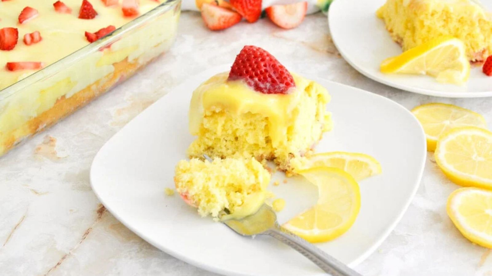 Sliced Lemon Strawberry Poke Cake on plate.