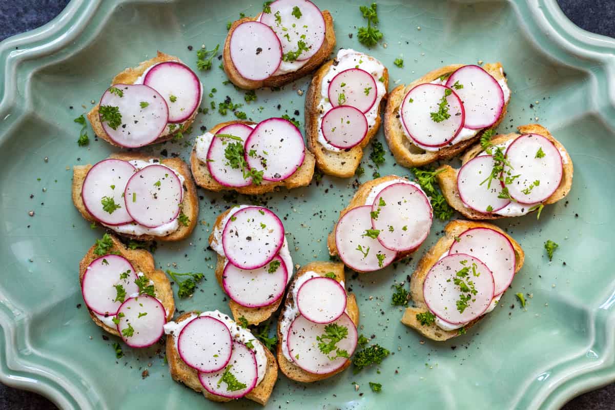 Crostini topped with ricotta, sliced radishes and sprinkled with fresh herbs.