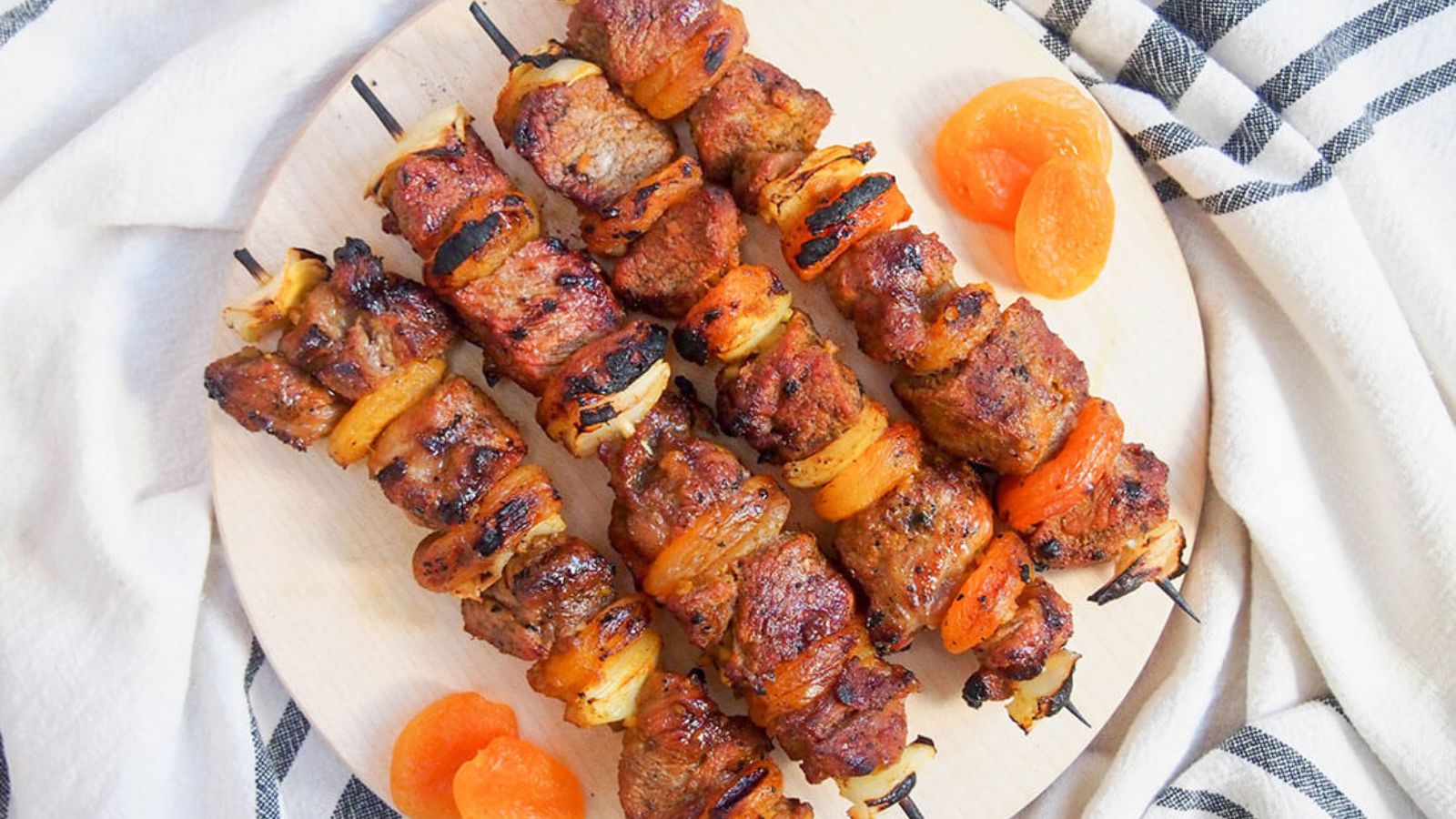 Lamb and apricot kabobs on a plate.
