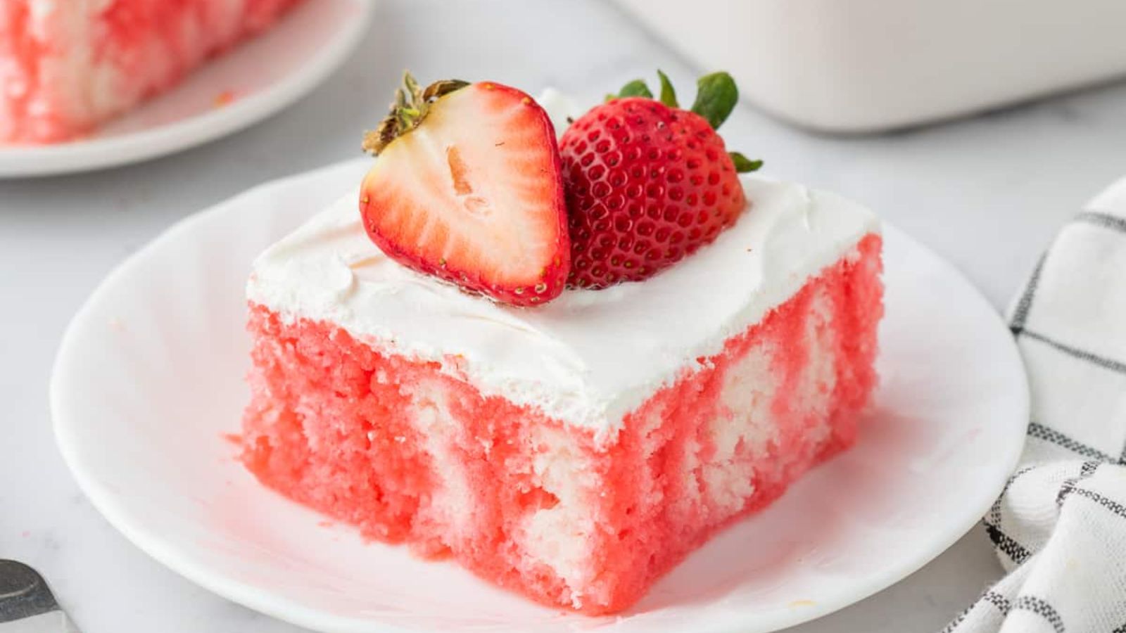 Close up shot of Strawberry Jello Poke Cake on a plate.