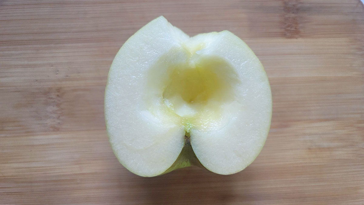 Core apple on a cutting board.