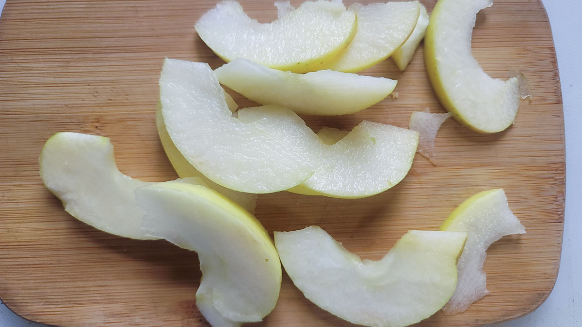 Apple slices on the wooden cutting board.