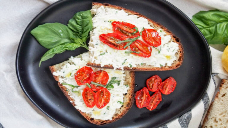 toast halves spread with ricotta and topped with tomatoes.