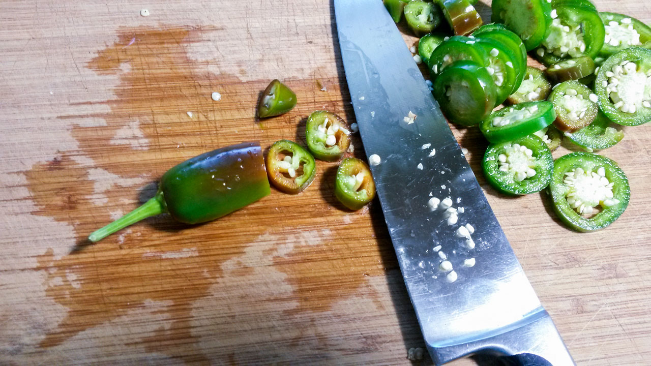 Sliced peppers on a cutting board with a chef's knife.