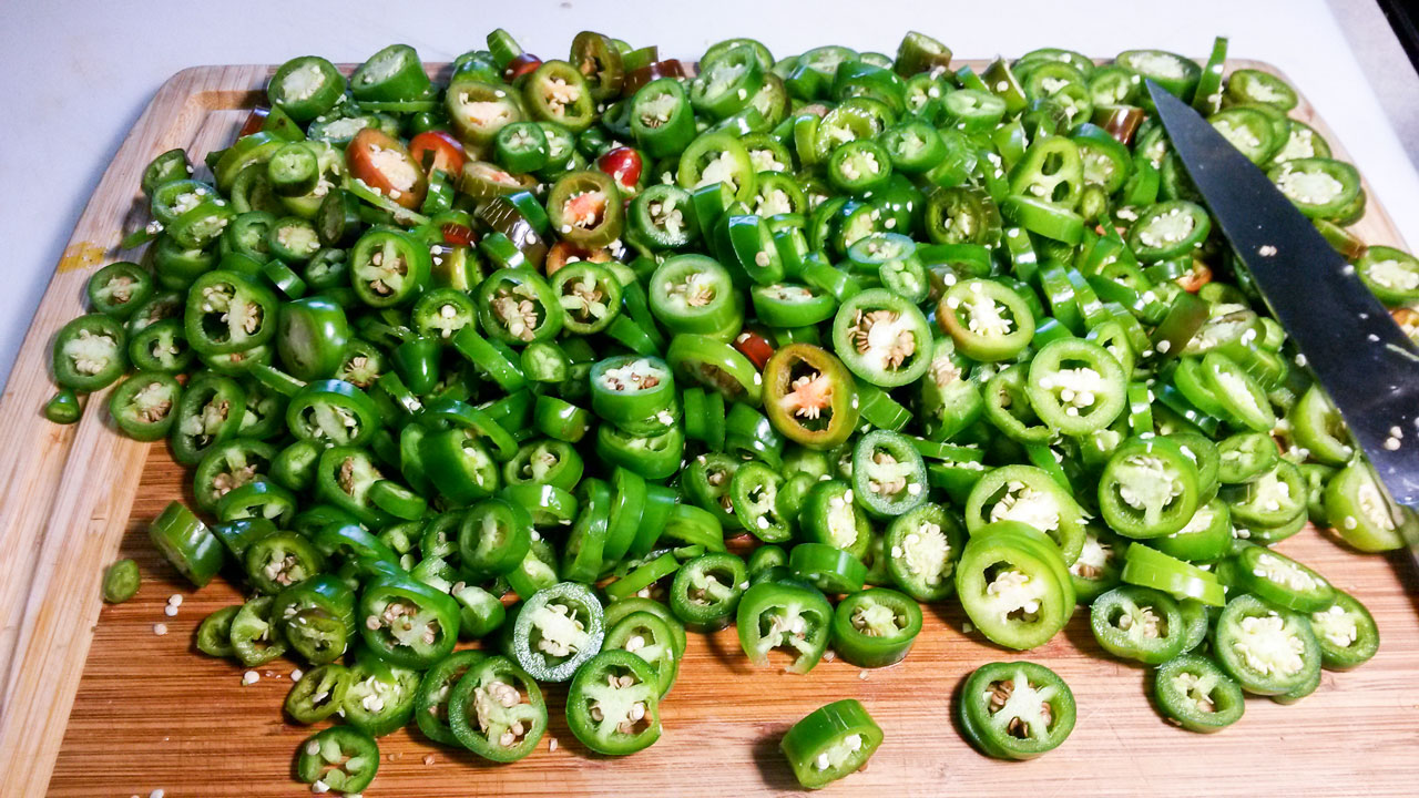 Large pile of sliced peppers on the cutting board.