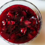Cherry pie filling in a clear glass bowl.