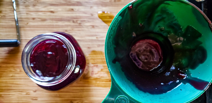 Filling jars with a canning funnel.