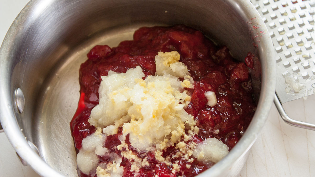 Jam, vinegar, onions and garlic added to a small pan.