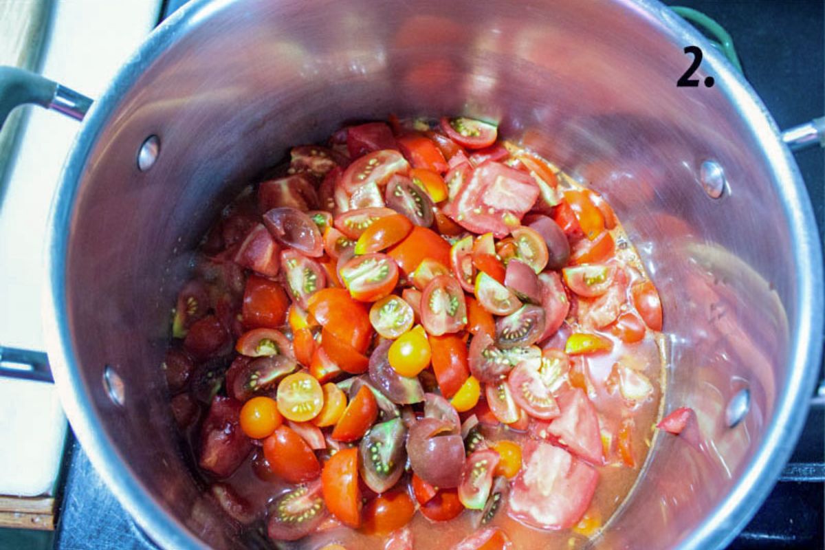 Tomatoes added to a large pot.