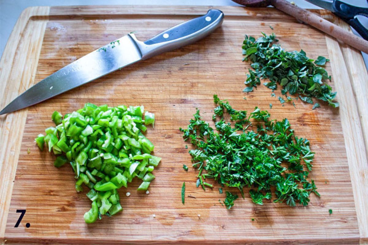 Chopped peppers, parsley and oregano on the cutting board.