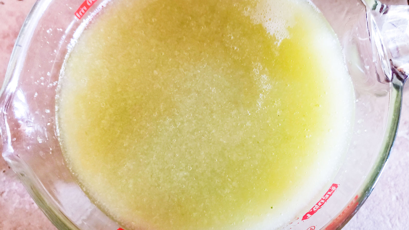 Cucumber juice in a measuring cup.