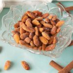 Clear glass bowl with honey roasted almonds in it.