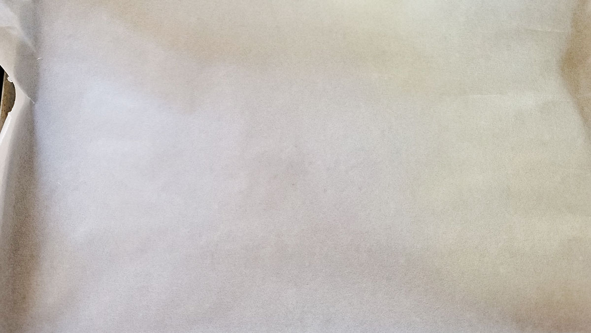 Rimmed baking dish covered with parchment paper.