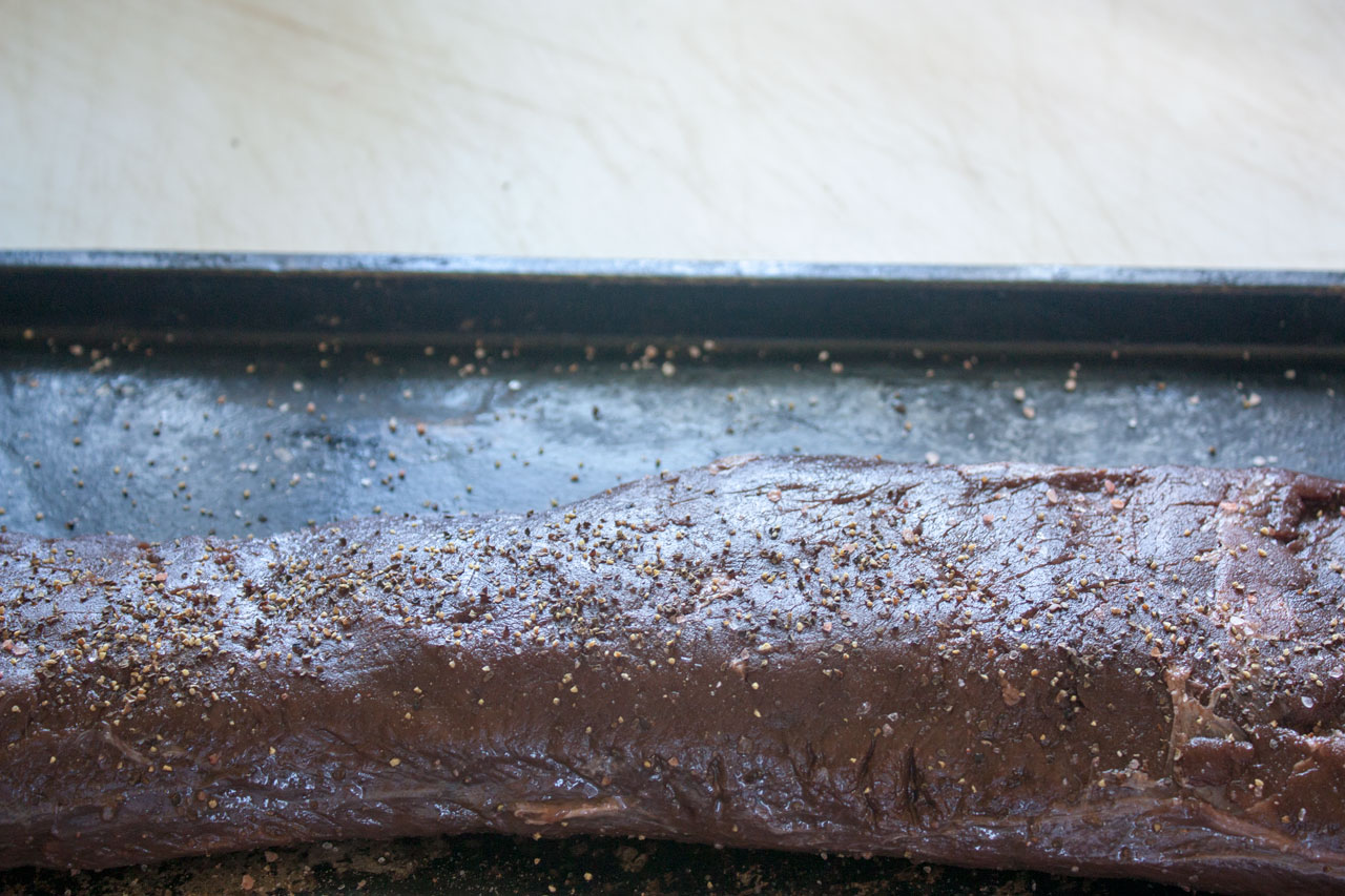 Seasoned meat of a metal baking tray.