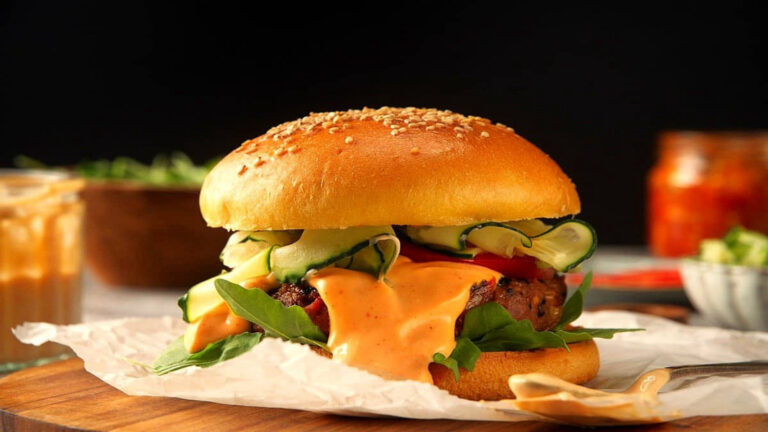 Kimchi Beef Burgers with sauce dripping out.