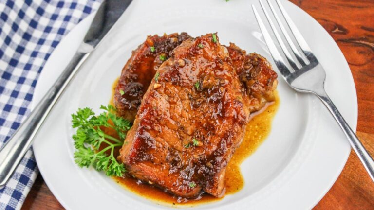 Pork chop with sauce on a plate.