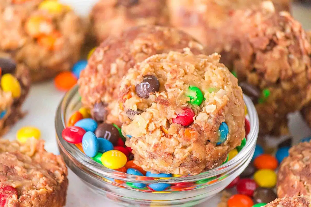 Monster cookies on top of a small glass bowl with M&Ms.