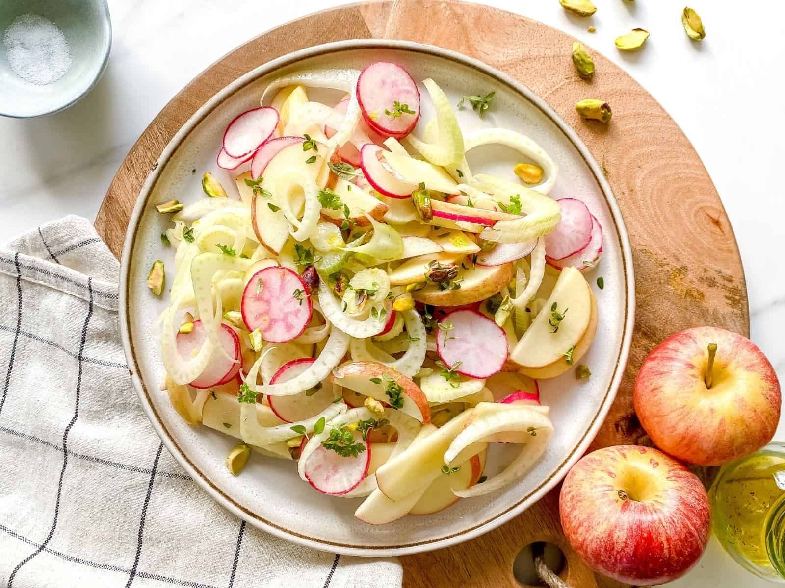 With with apple, fennel and radish salad with whole apples on the side.
