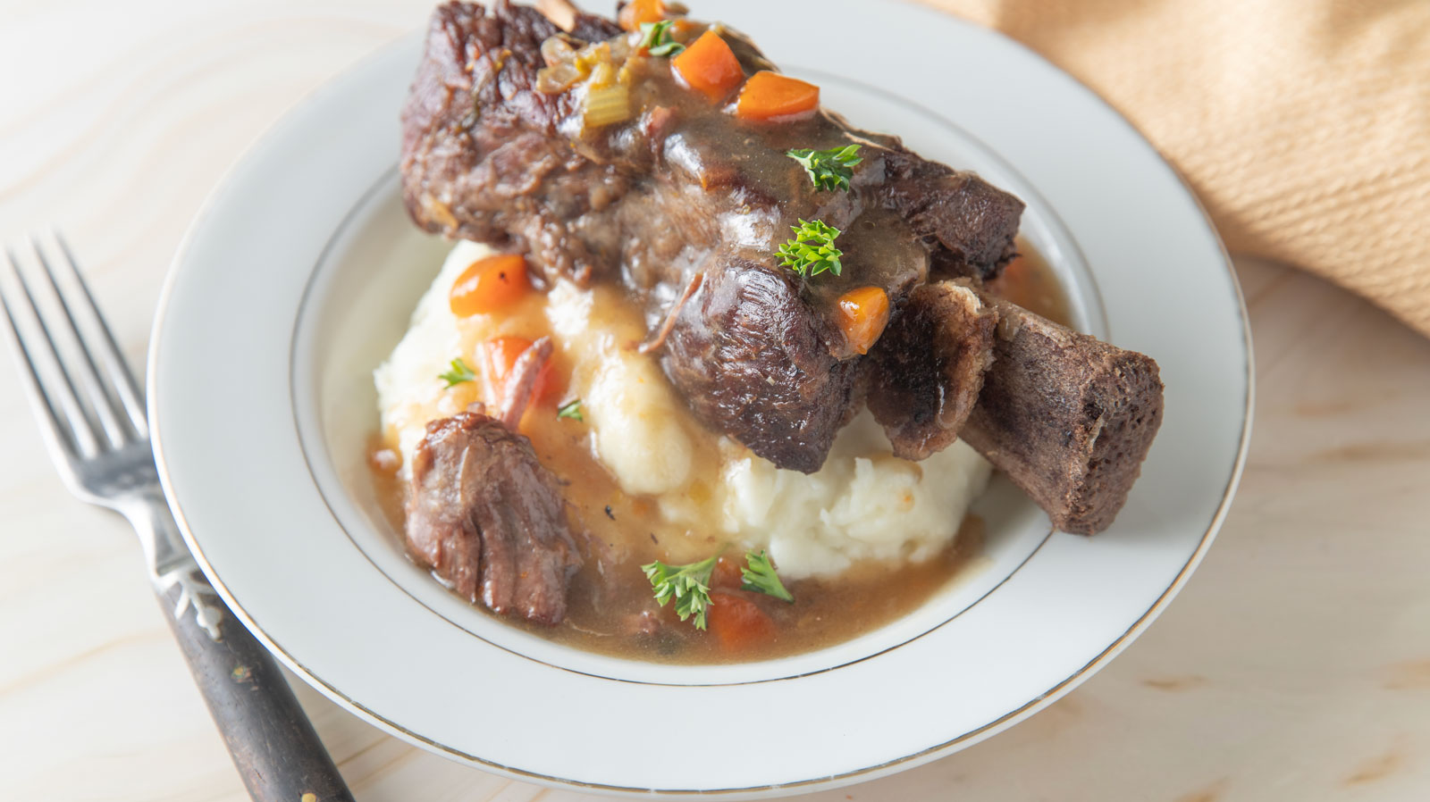 Mashed potatoes topped with beef rib and gravy.