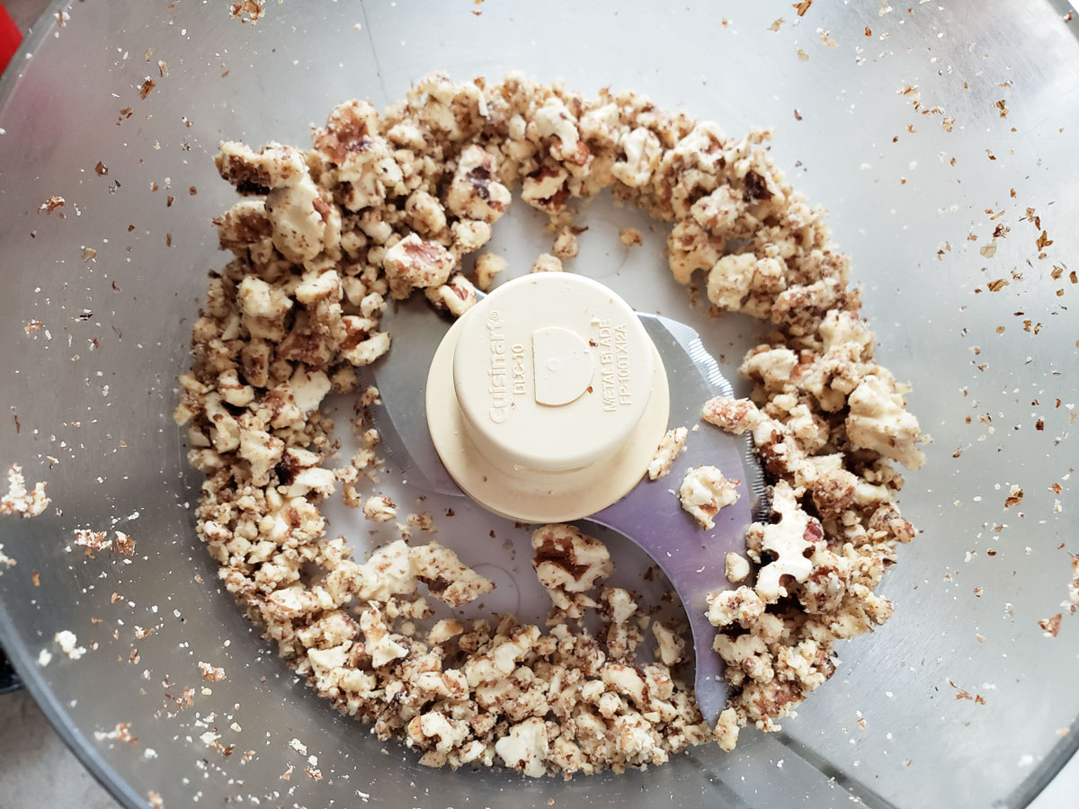 Chopped up nuts in a food processor bowl.